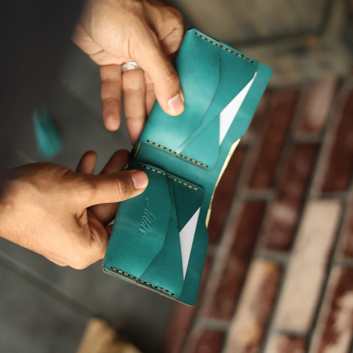 Card being drawn from the Aether blue leather bifold wallet